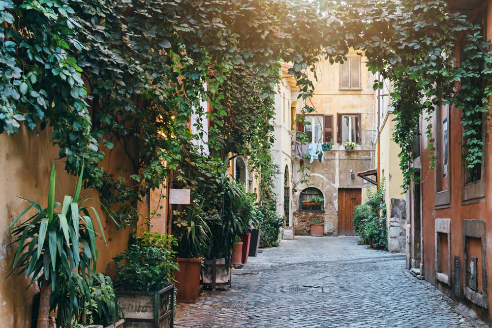 Italiensk gränd med blommor och tegelbyggnader